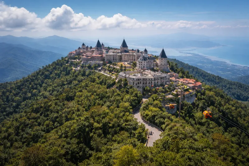 Aerial view of the Ba Na Hills French Village castle complex above forested mountains near Da Nang