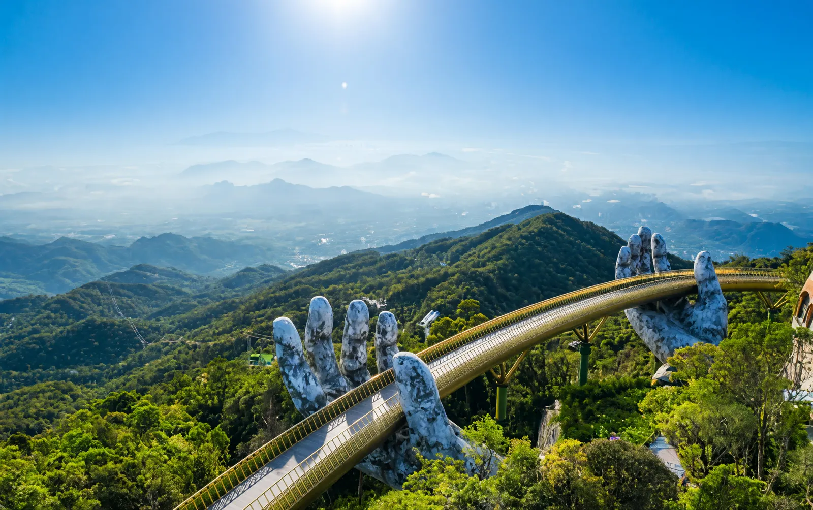 Golden Bridge held by giant stone hands at Ba Na Hills, Da Nang, with mountain views